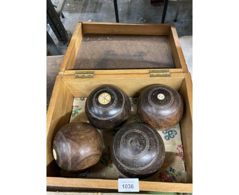 A VINTAGE PINE BOX CONTAINING FOUR BOWLING BOWLS 