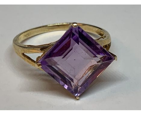 A 10 CARAT GOLD RING WITH A PURPLE DIAMOND SHAPED STONE SIZE O 