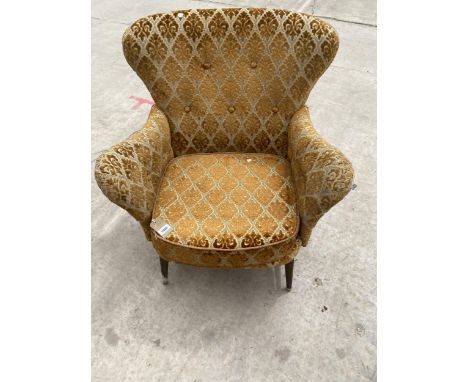 AN ERCOL BLUE LABEL SMALL WINGED FIRESIDE CHAIR WITH SHAPED ARMS, ON TURNED FRONT LEGS AND STRETCHERS 