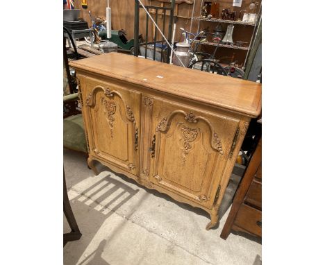 A CONTINENTAL OAK CABINET WITH TWO CARVED PANEL DOORS, 48" WIDE 