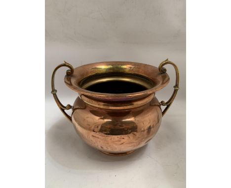 A VINTAGE BRASS AND COPPER TWIN HANDLED POT 