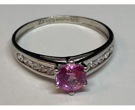 A 9 CARAT WHITE GOLD RING WITH A PINK SAPPHIRE AND CUBIC ZIRCONIAS ON THE SHOULDERS SIZE M/N 