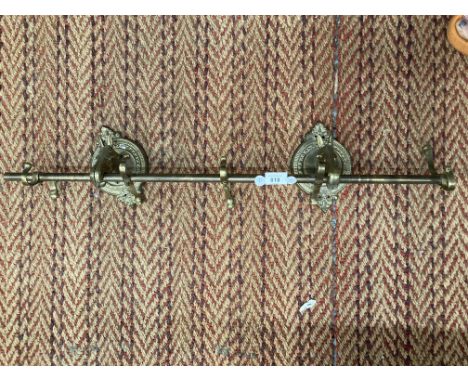 A VINTAGE BRASS CURTAIN POLE WITH HORSE HEAD BRACKETS