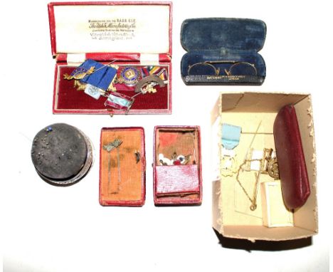 A box containing silver gilt and other medals; spectacles; stick pins etc.