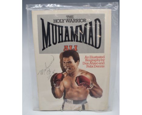 Muhammad Ali signed illustrated biography 'The Holy Warrior Muhammad Ali', signed and dated Dec 18 80 to left hand side, seal