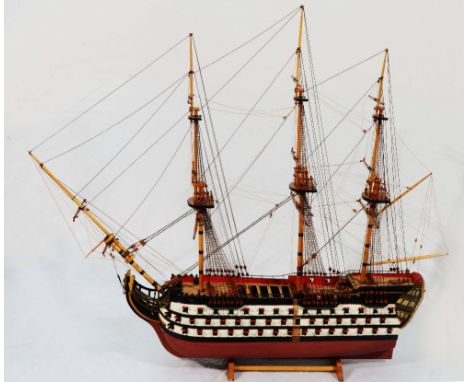 A 20TH CENTURY WOODEN MODEL of HMS Victory fully rigged and with painted details and wooden stand, 76cm high, approximately 8