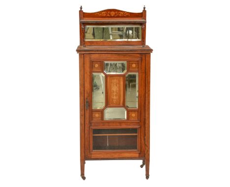 An Edwardian rosewood and inlaid music cabinet, with mirror inset upstand, the partly glazed panelled door also with bevelled