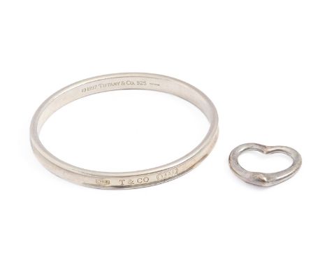 Tiffany &amp; Co. A silver bangle and heart shaped pendant, the latter designed by Elsa Peretti, bangle 63mm (internal), make