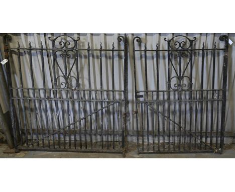 Two matching Edwardian wrought garden or park gates,&nbsp; with 'flame' or scroll terminals and braced dog bars, 137cm h, 135