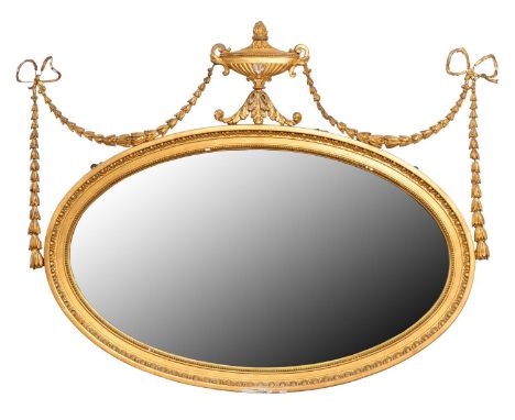 An Edwardian oval neo classical giltwood and composition mirror,&nbsp;surmounted by an urn and festoons, 80 x 98cm  Losses