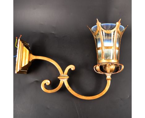 An English Edwardian brass and opalescent glass wall light, the scrolled branch supporting a glass shade held within a corone