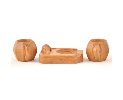 Robert 'Mouseman' Thompson of Kilburn, a pair of carved oak octagonal napkin rings, 5cm; and an ashtray, 10cm, each with carv