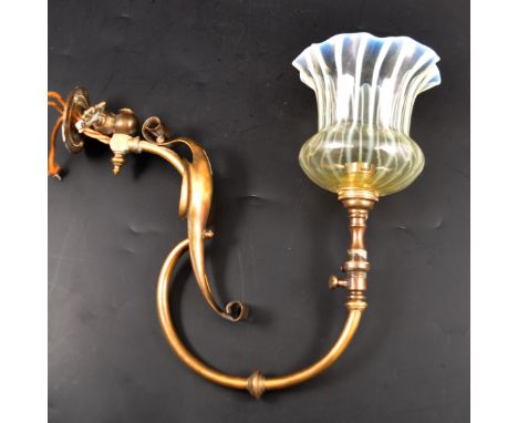 An English Edwardian brass and opalescent glass wall light, the scrolled branch supporting a glass shade with wavy rim and st
