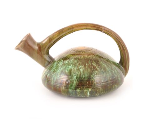 A pottery ewer designed by Dr Christopher Dresser for Linthorpe Art Pottery, with loop handle over a squat body, incised by g