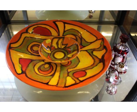 A Poole, England circular iron ground ceramic charger with isometric multicoloured designs, 41cm diameter (slight chip to rim