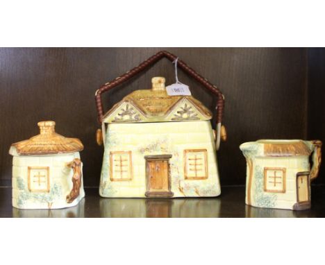 A mid 20th century Keele Street ceramic tea caddy with lid in the form of a little cottage with a matching lidded sugar bowl 