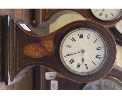 An Edwardian mahogany inlaid mantle clock with of wasted form with circular dial, Roman numerals on a shaped oblong base with