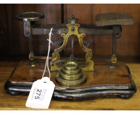 A Victorian brass and mahogany post office weighing scales with weights on a shaped base
