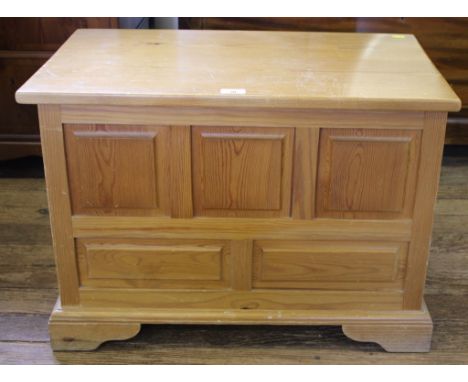 An oblong pine storage trunk, or blanket chest, of oblong form with lift up lid, panelled front, raised on bracket feet 50H x