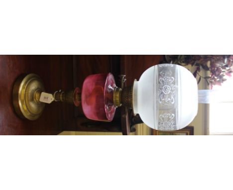 A Victorian oil lamp with cranberry glass bowl, etched shade with chimney on a circular brass base, 63cm high