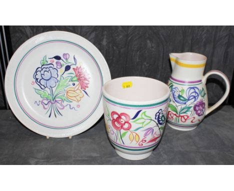 A trio of Poole pottery ceramics, to include a circular plate, a vase and jug with similar multicoloured floral and foliate d