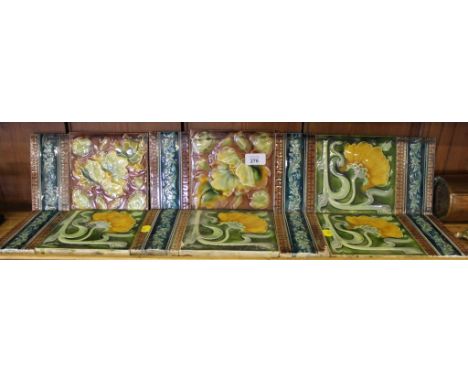 A selection of six ceramic Arts and Crafts multicoloured tiles with eight borders with embossed floral depictions, each 16 cm