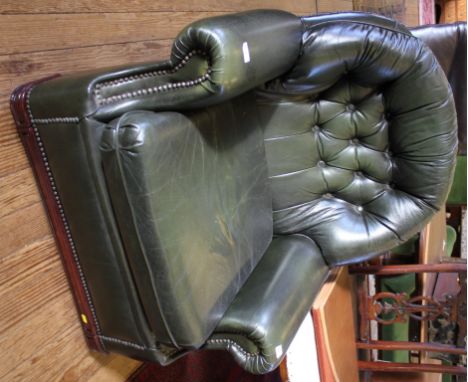 A mahogany framed green leather upholstered easy chair with button back support, shaped arm rests and swab cushion