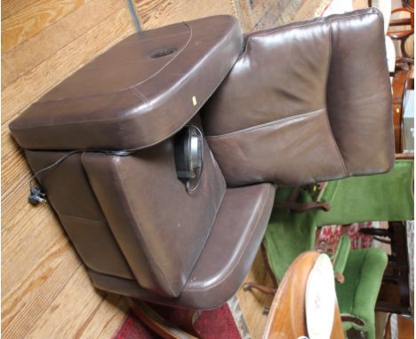 A Dewert electrically operated adjustable arm chair with brown leather upholstery, rounded arm rest and cushion 