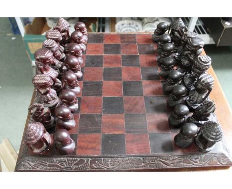 A carved wooden African figural chess set and board