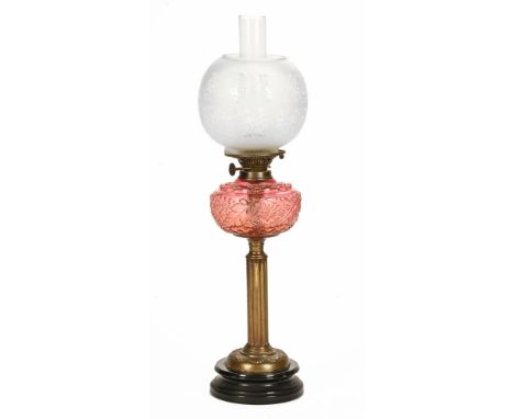 A Victorian oil lamp, with etched shade, moulded reservoir and brass column.  Height including chimney 70 cm.