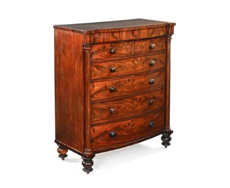 A Victorian flame mahogany Scotch chest, two short and four long bowed and beaded chest of drawers flanked by turned pillars 