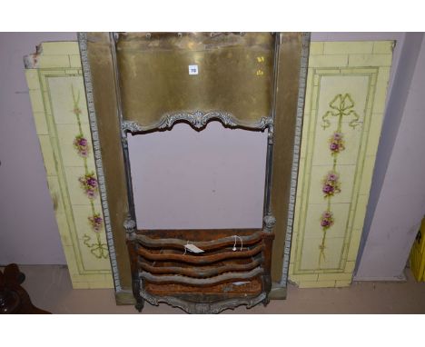 A brass fire surround, c.1900, flanked by floral glazed tiles.