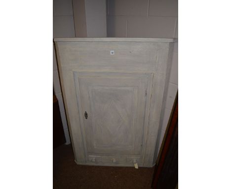 A grey painted corner hanging corner cabinet, the diamond-shaped panel door above single drawer and two dummy handles.