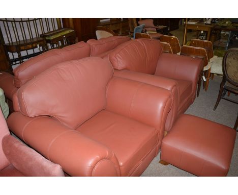 A four-piece drawing room suite in red leather, to include: a sofa, two chairs and an ottoman.