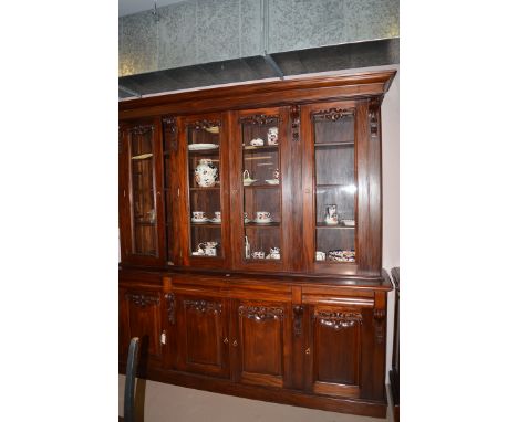 A reproduction Victorian style mahogany display cabinet, the flared cornice above four glazed panel doors, the base fitted fo