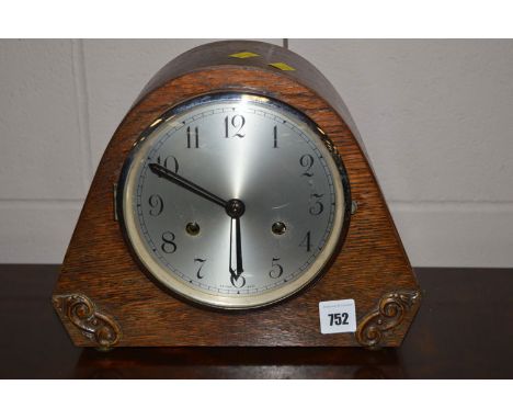 An oak cased mantle clock with silvered arabic dial.