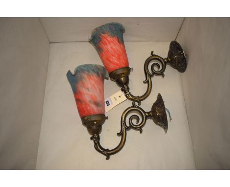 A pair of modern light sconces, with mottled red and blue glass shades.