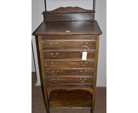 An early 20th Century stained wood music cabinet, fitted five fall-front drawers, 52cm wide.