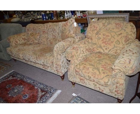 A two-seater sofa and matching armchair, upholstered in floral scrolling material, purchased recently at Dickinson's, Hexham.