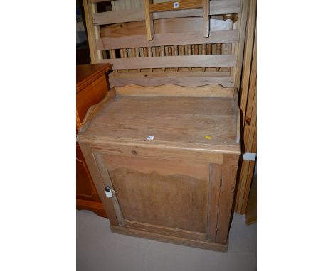 A  stripped pine cabinet, rectangular top with 3/4 shaped gallery above panelled door, 72cms wide.