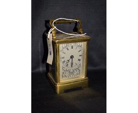 A 20th Century brass carriage clock by Elliott, roman dial with floral design.
