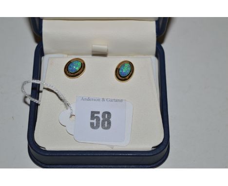 A pair of opal stud earrings, the oval cabouchons in yellow metal mounts, stud and butterfly fitting.