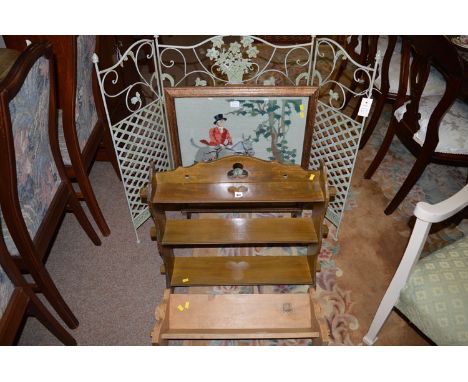 A hanging shelf unit; a book trough; a firescreen with hunting scene; and a painted metal trellis work garden screen.  (4)