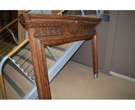 A dark stained hard wood fire surround, the flared cornice above egg and dart decoration and acanthus carved frieze flanking 