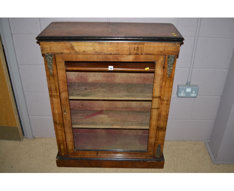 A Victorian burr walnut and ebonised cabinet, the glazed panel door flanked by stringing and brass mounts, 80cm wide.