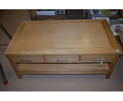 A modern light stained wood coffee table fitted three frieze drawers above undertier, 110cms wide.