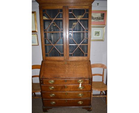 A George III oak bureau bookcase, fitted a pair of glazed astragal doors enclosing shelves above fall-flap enclosing pigeonho