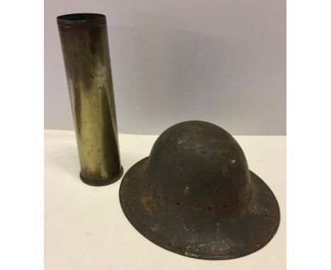 WW2 air raid wardens metal helmet together with a WW2 shell casing.  