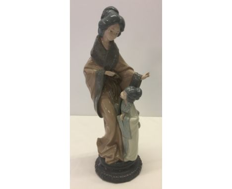 A Ceramic figurine of an oriental lady and child by Nao. Small damage to fingers on one hand. Approx 38.5 cm tall.