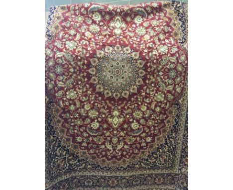 A large Keshan ground carpet of red colouration. With black brown and beige design to outside. Approx 280 x 200cm. 